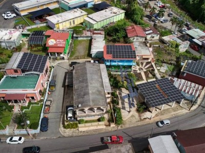 Aerial view of colorful buildings with solar panels that make up an urban solar microgrid project.