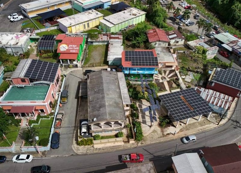 Aerial view of colorful buildings with solar panels that make up an urban solar microgrid project.